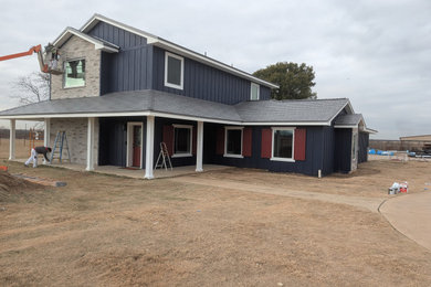 Example of a large blue two-story board and batten exterior home design in Dallas with a shingle roof and a gray roof