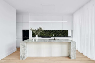 Diseño de cocina actual grande con salpicadero de vidrio templado, una isla y encimeras blancas