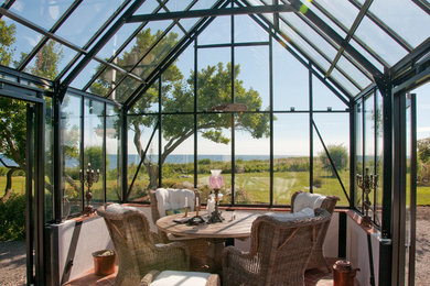 Example of a small classic brick floor sunroom design with a glass ceiling