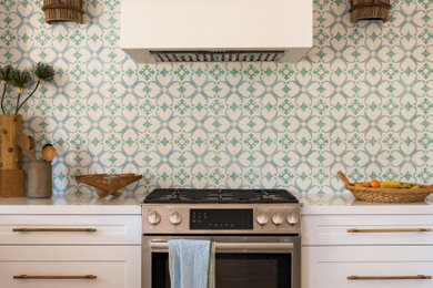 Example of a mid-sized eclectic l-shaped medium tone wood floor and shiplap ceiling kitchen design in San Diego with a single-bowl sink, shaker cabinets, white cabinets, quartz countertops, multicolored backsplash, cement tile backsplash, stainless steel appliances, no island and white countertops