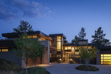 Inspiration for a contemporary house exterior in Denver with stone veneer and a flat roof.