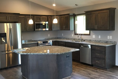 Modern open plan kitchen in Other with a double-bowl sink, shaker cabinets, distressed cabinets, granite benchtops, stainless steel appliances, medium hardwood floors, with island and brown floor.
