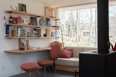 Photo of a modern home office in Tokyo with white walls, a built-in desk and black floor.