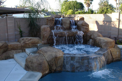 Inspiration for a mid-sized timeless backyard concrete paver and custom-shaped pool fountain remodel in Los Angeles