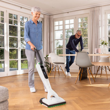 Wohnzimmer mit großen Fenstern und Laminatboden
