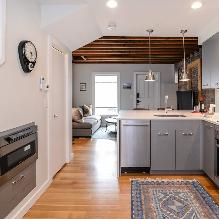 Along the opposite wall, space underneath the staircase is utilized as bonus room for an undercounter microwave drawer and storage. A walk-in pantry is also located under the highest part of the stair