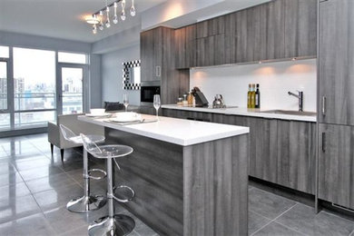 Inspiration for a small contemporary l-shaped eat-in kitchen remodel in Toronto with an undermount sink, gray cabinets, granite countertops, white backsplash and stainless steel appliances