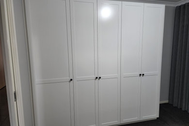 Photo of a storage and wardrobe in Melbourne with shaker cabinets and white cabinets.