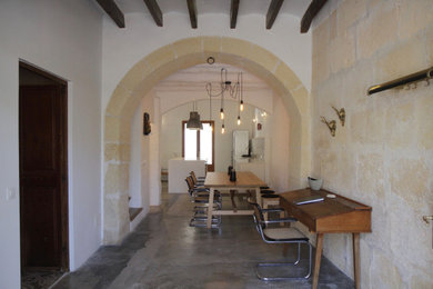 Modelo de puerta principal mediterránea con paredes blancas, suelo de travertino, puerta doble, puerta de madera en tonos medios y vigas vistas