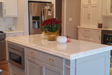 Mid-sized trendy u-shaped light wood floor eat-in kitchen photo in Raleigh with an undermount sink, marble countertops, white backsplash, subway tile backsplash, stainless steel appliances, an island, beaded inset cabinets and blue cabinets