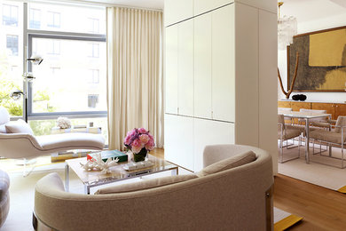 Mid-sized trendy open concept light wood floor living room photo in New York with white walls, no fireplace and a concealed tv