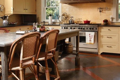 Large elegant u-shaped slate floor eat-in kitchen photo in New York with an undermount sink, shaker cabinets, yellow cabinets, granite countertops, yellow backsplash, ceramic backsplash, stainless steel appliances and an island