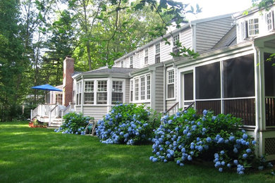 Large traditional gray two-story gable roof idea in Boston