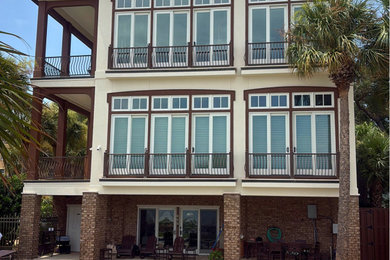 Example of a three-story stucco house exterior design in Jacksonville