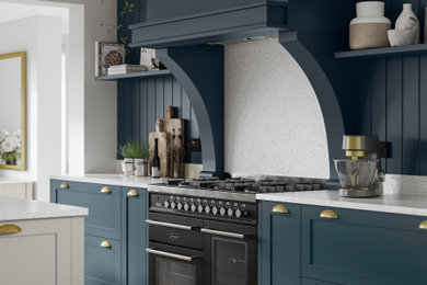 Inspiration for a medium sized classic grey and teal galley open plan kitchen in Berkshire with shaker cabinets, blue cabinets, quartz worktops, white splashback, granite splashback, black appliances, an island, white worktops, a built-in sink, laminate floors, beige floors and a feature wall.