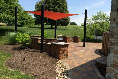 Sail shade over a paver patio and a gas firepit