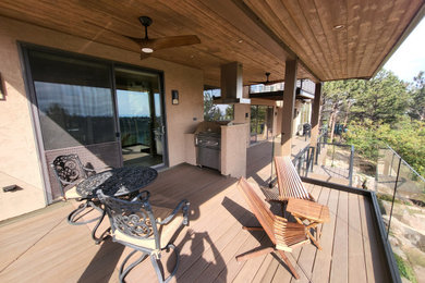 Inspiration for a huge timeless backyard second story glass railing deck remodel in Denver with a roof extension