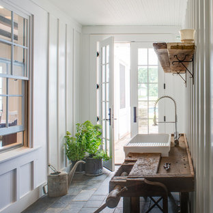 Esempio di un ingresso o corridoio country con pareti bianche, una porta in vetro e pavimento in ardesia