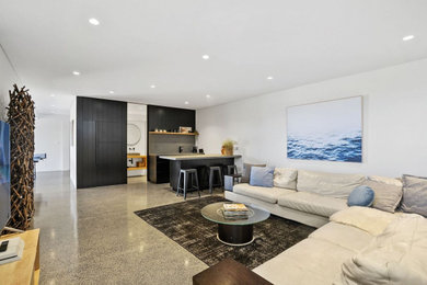 This is an example of a mid-sized beach style enclosed family room in Sydney with a game room, white walls, concrete floors and no tv.