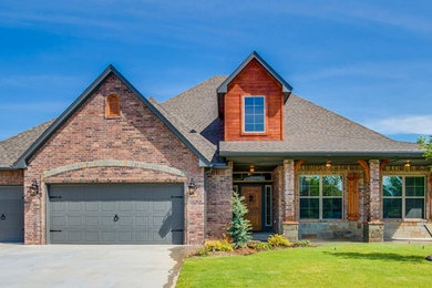 Inspiration for a large rustic multicolored two-story brick exterior home remodel in Oklahoma City with a shingle roof