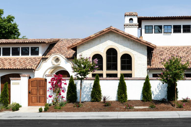 Inspiration for a mid-sized mediterranean white two-story brick house exterior remodel in San Francisco with a shed roof and a tile roof