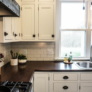 Inspiration pour une petite arrière-cuisine rustique en U avec un évier posé, un placard à porte shaker, des portes de placard blanches, une crédence blanche, une crédence en carrelage métro, un électroménager en acier inoxydable, un sol en bois foncé, un îlot central, un sol marron et un plan de travail en zinc.