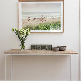 Immagine di un ingresso o corridoio stile marino di medie dimensioni con pareti bianche, pavimento in bambù, pavimento marrone e una porta in legno bruno