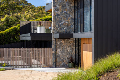 Photo of a large and australian native contemporary front yard full sun xeriscape in Other with gravel and a wood fence.