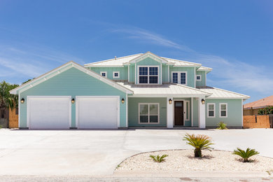 Example of a large beach style green two-story wood gable roof design in Austin
