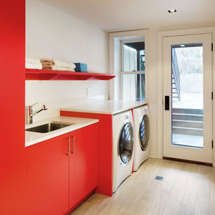 Foto de lavadero lineal, contemporáneo, con armarios con paneles lisos, puertas de armario rojas, lavadora y secadora juntas y encimeras blancas