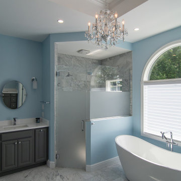 Traditional master bath utilizing frosted and clear glass to allow for needed pr
