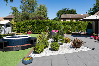 Idée de décoration pour un jardin arrière de taille moyenne et l'été avec une exposition ensoleillée et des pavés en béton.