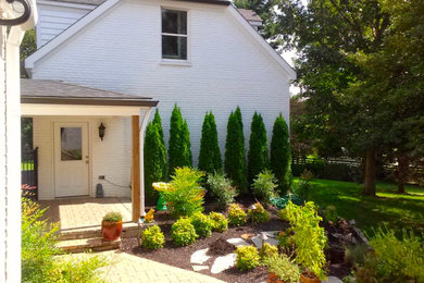 Photo of a large traditional partial sun backyard concrete paver formal garden in Louisville.