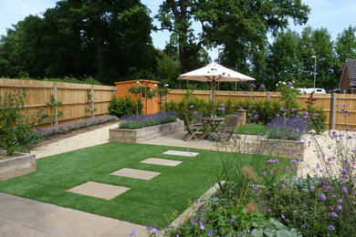 This is an example of a mid-sized contemporary backyard full sun garden in Hertfordshire with natural stone pavers and a container garden.