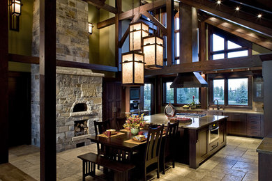 Open concept kitchen - large craftsman u-shaped travertine floor open concept kitchen idea in Calgary with a farmhouse sink, shaker cabinets, dark wood cabinets and an island