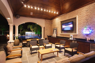 Example of a large mountain style backyard concrete paver patio design in Houston with a gazebo