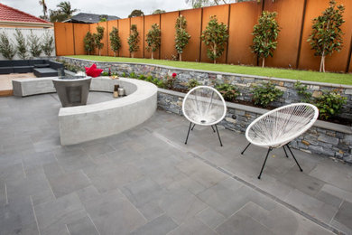 Inspiration for a mid-sized contemporary courtyard patio in Melbourne with a fire feature and natural stone pavers.