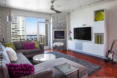 Inspiration for a mid-sized contemporary open concept medium tone wood floor living room remodel in San Diego with red walls, a tile fireplace and a wall-mounted tv