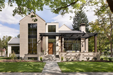 Foto de fachada de casa beige y gris contemporánea de dos plantas con tejado de metal, revestimientos combinados y tejado a dos aguas