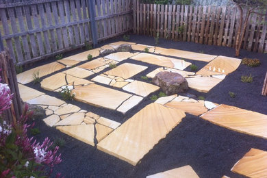 Photo of a small eclectic backyard garden in Hobart with natural stone pavers.