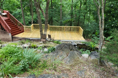 This is an example of a large traditional backyard deck in Raleigh with no cover.
