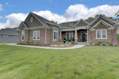 Mid-sized minimalist beige two-story brick exterior home photo in Chicago with a tile roof