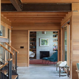 This is an example of a large beach style hallway in Boston with beige walls and concrete floors.