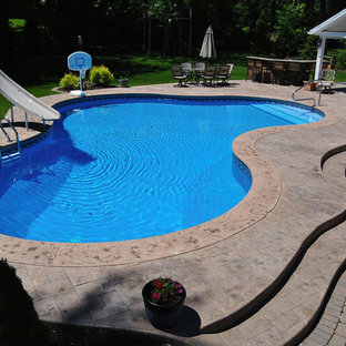 Pool hinter dem Haus in individueller Form mit Wasserrutsche und Stempelbeton in Boston