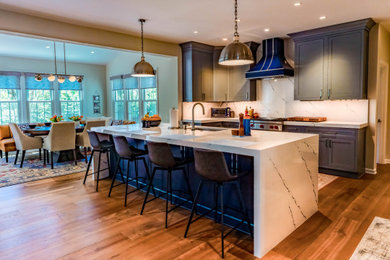 Example of a large transitional l-shaped medium tone wood floor and brown floor open concept kitchen design in Baltimore with an undermount sink, shaker cabinets, blue cabinets, quartz countertops, blue backsplash, quartz backsplash, colored appliances, an island and blue countertops