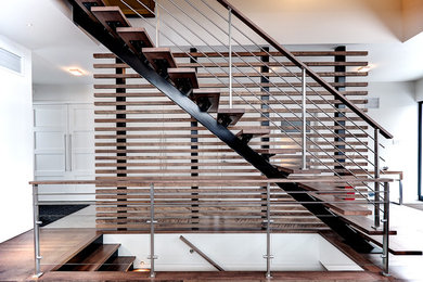 Contemporary wood straight staircase in Montreal with open risers.