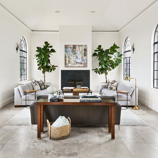 Inspiration for a mediterranean living room in Portland with white walls, a standard fireplace and grey floors.