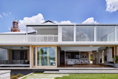 Mid-sized contemporary two-storey concrete white house exterior in Brisbane with a gable roof, a metal roof, a white roof and clapboard siding.