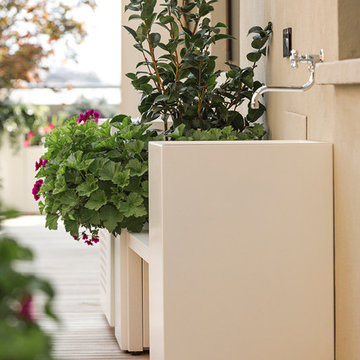 Terrazzo importante con pavimento in teak, fioriere perimetrali e arredi