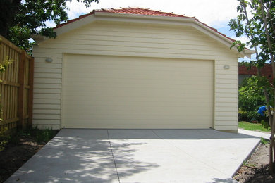 На фото: отдельно стоящий гараж среднего размера для двух машин